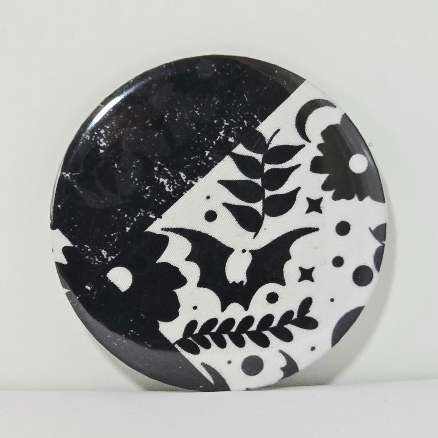 Round black and white patterned object on a light gray background