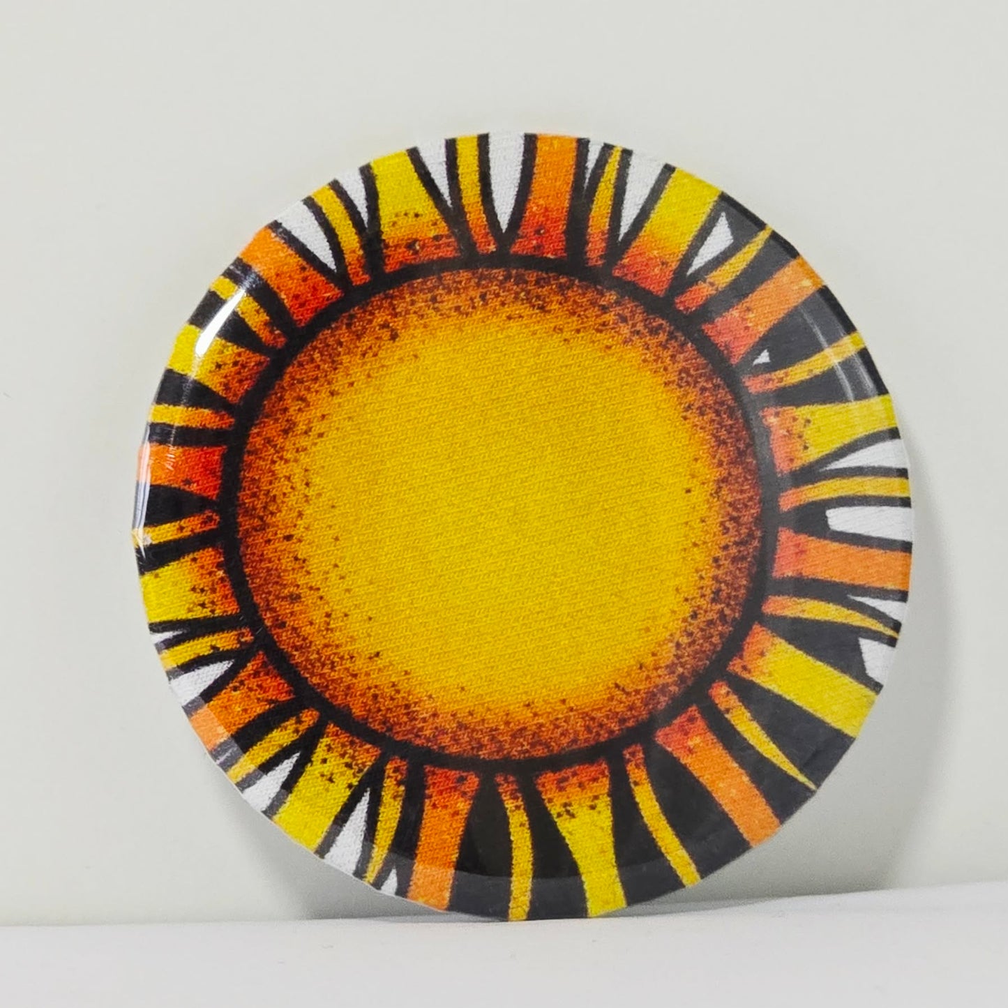 Decorative magnet with sun design on a white background