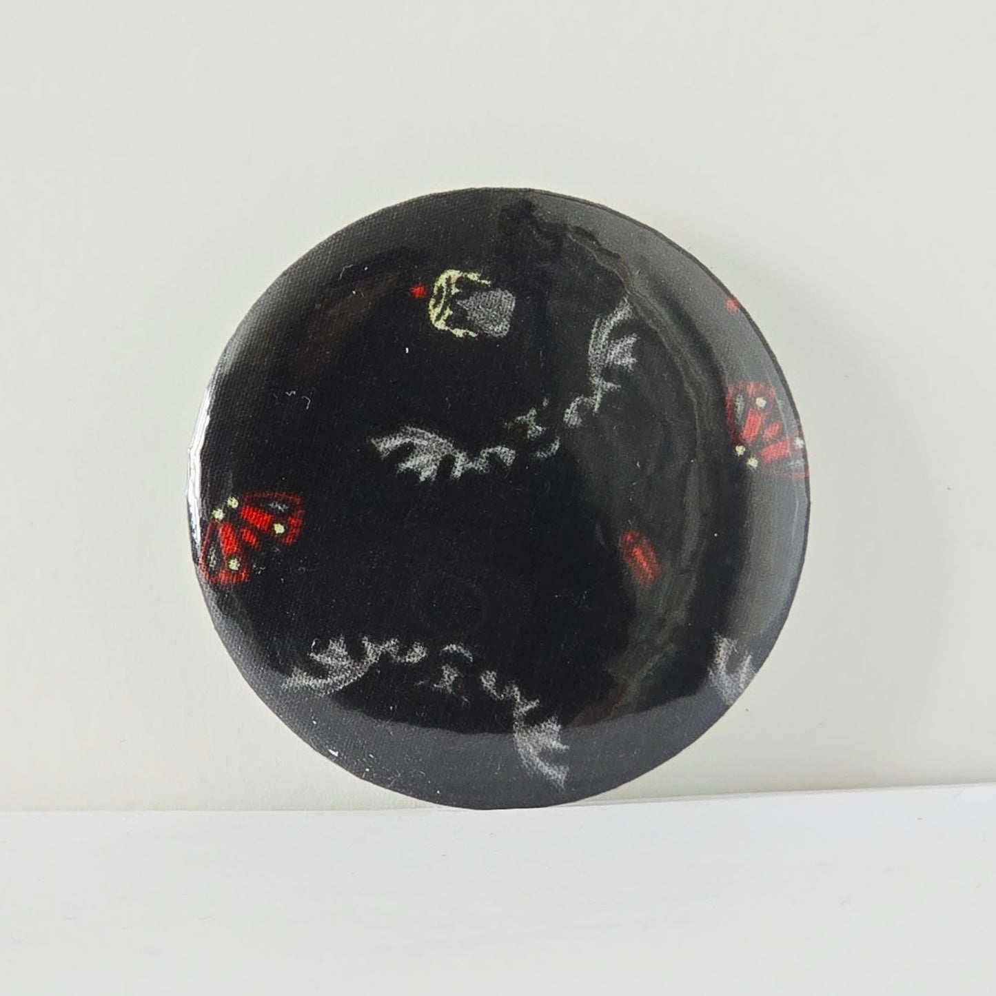 Black circular object with white and red designs on a white background