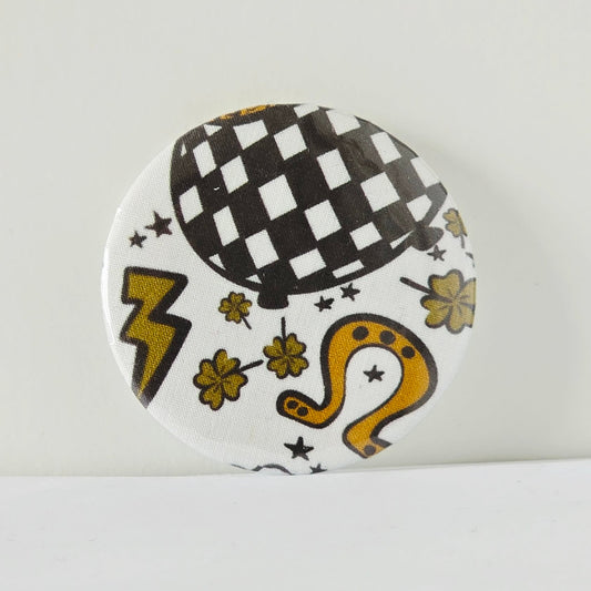 Circular badge with black and white checkered design, yellow accents, and decorative elements on a white background.