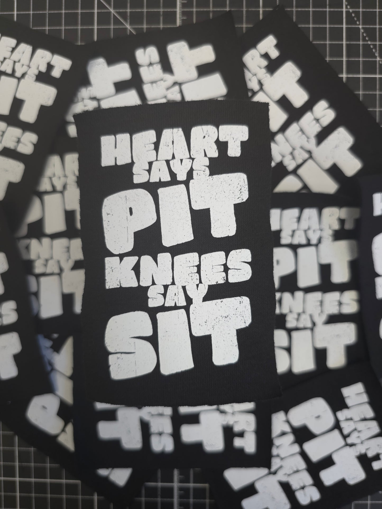 Stack of black stickers with white text on a grid background