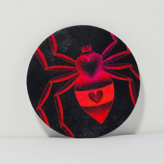 Circular black and red fabric patch with spider design on a white background