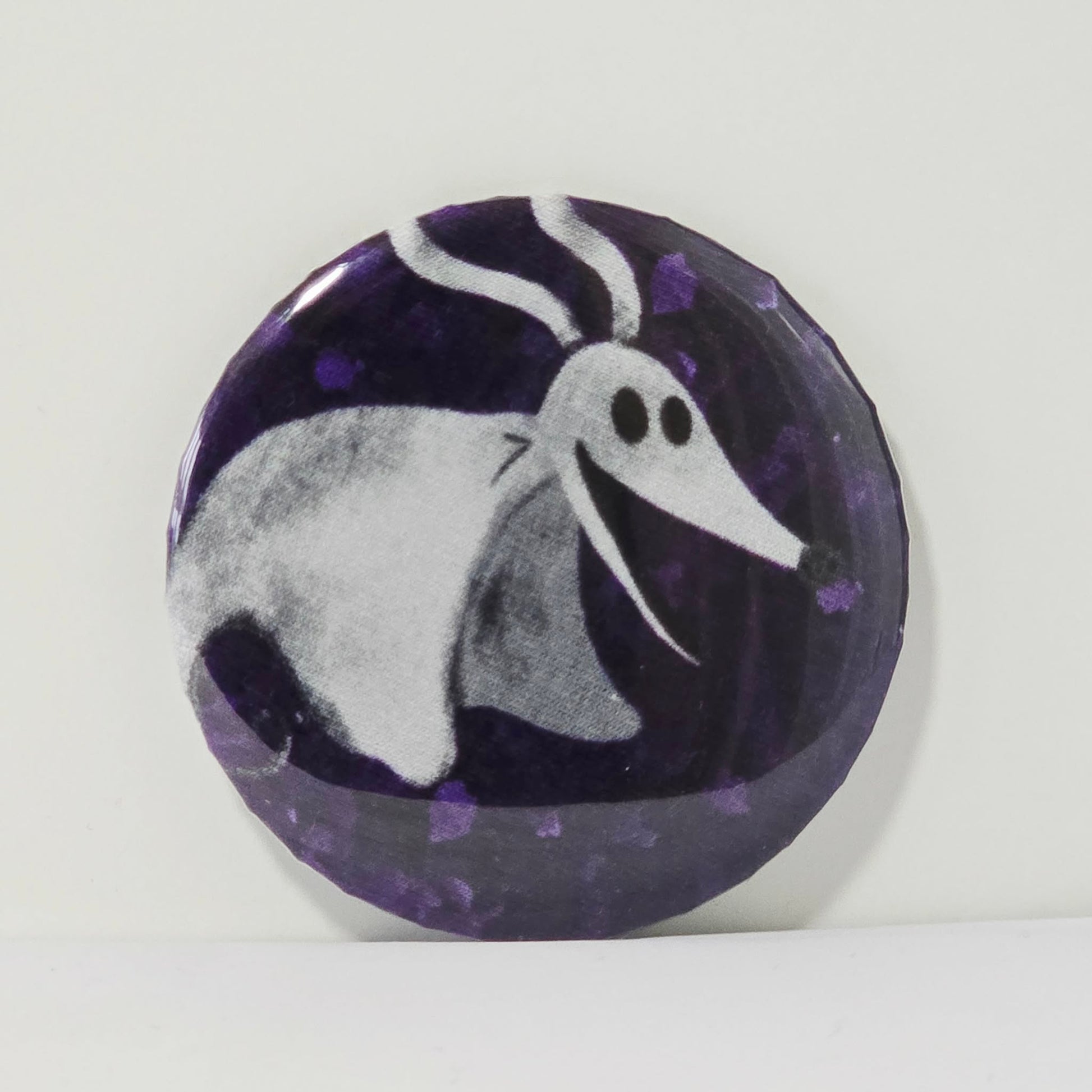 Button badge with a ghostly dog design on a purple background
