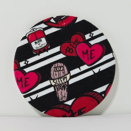 Round product with black and white striped pattern, red hearts, and text on a white background