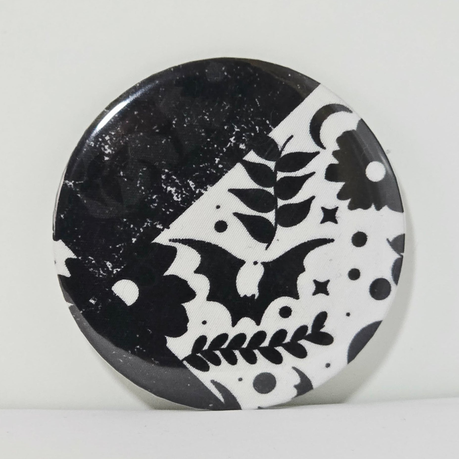Round black and white patterned object on a light gray background