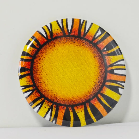 Decorative magnet with sun design on a white background
