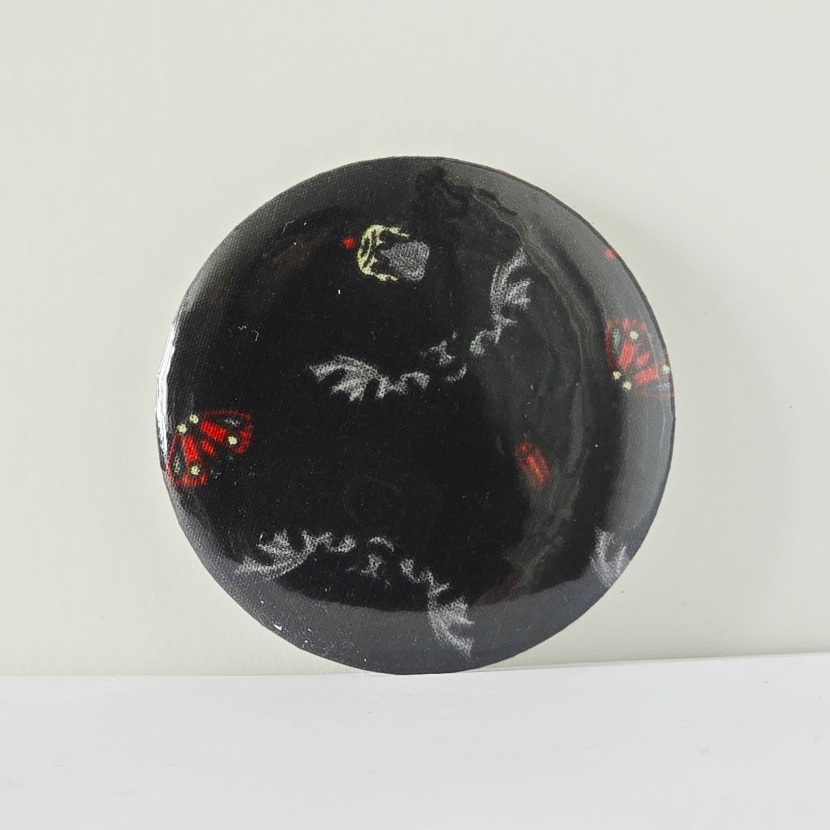 Black circular object with white and red designs on a white background