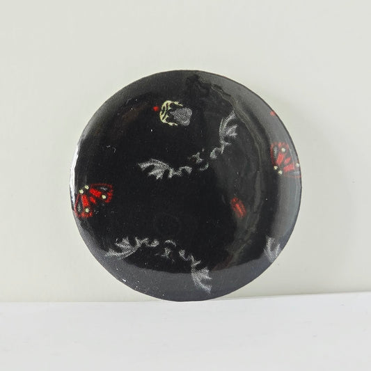 Black circular object with white and red designs on a white background