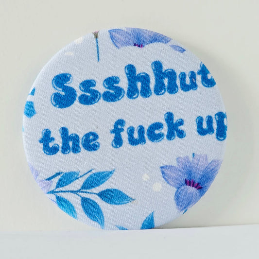 Round magnet with blue floral design and text on a white background