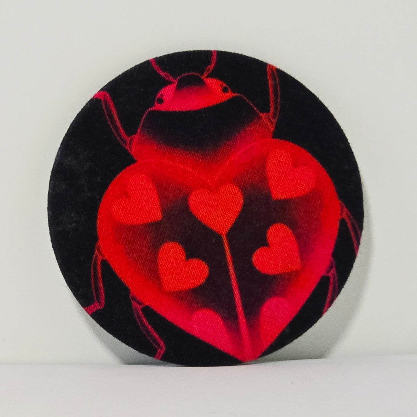 Circular object with red heart design on a black background