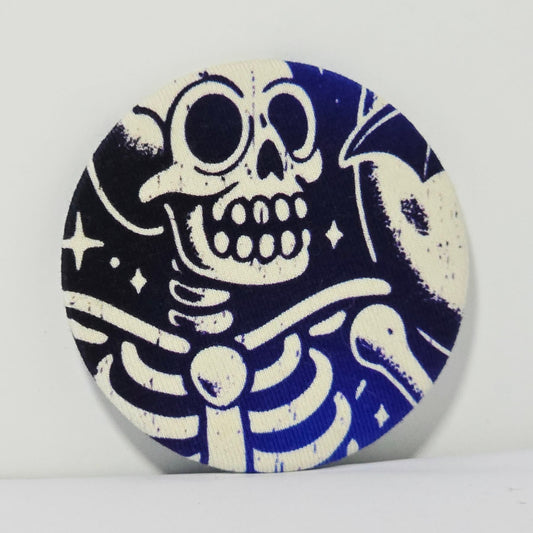 Round ceramic magnet with a blue and white skeleton design on a blue background