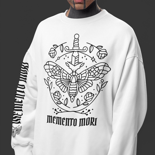 Person wearing a white sweatshirt with a black graphic design and 'memento mori' text on a dark background